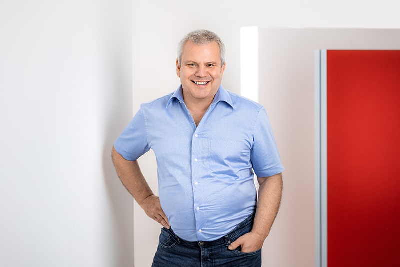 Mitarbeiter lächelt in einem modernen Büro. Fokus auf C-Artikel-Management und E-Procurement von Schröter GmbH.