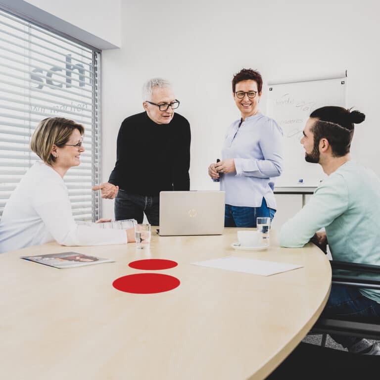 Mitarbeiter der Schröter GmbH besprechen C-Artikel-Management-Strategien in einem modernen Büro.