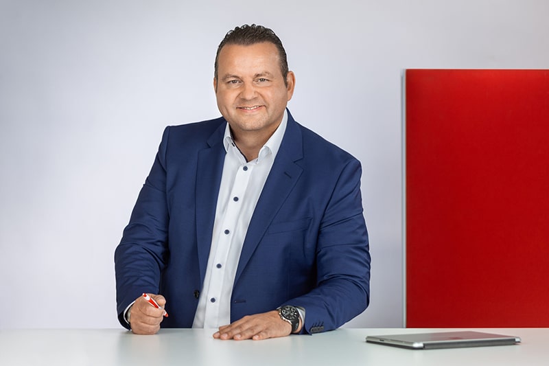 Mitarbeiter in blauem Anzug am Schreibtisch, Darstellung von Schröter GmbH, Experten für C-Artikel-Management.