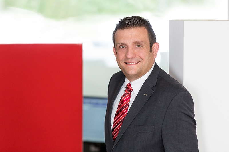 Ein Schröter-Team-Mitglied lächelt in einem modernen Büro von Schröter GmbH, Spezialist für C-Artikel-Management.